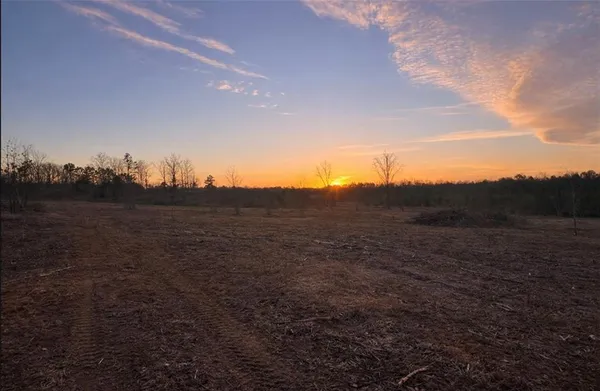 a view of a field with wooden fence
