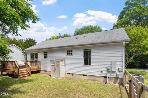 a view of a house with a yard deck and a patio