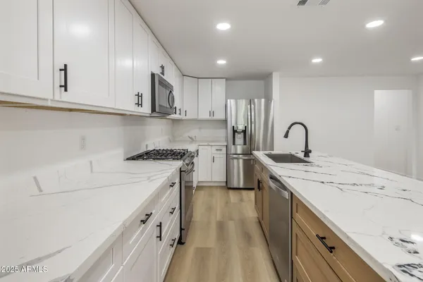 a kitchen with a sink a stove and cabinets