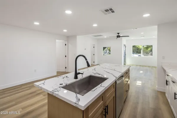 a kitchen that has a sink a stove and a table in it