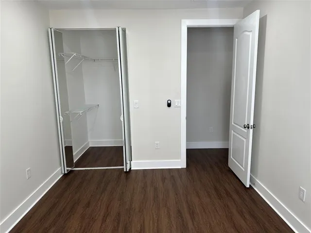 an empty room with wooden floor and closet