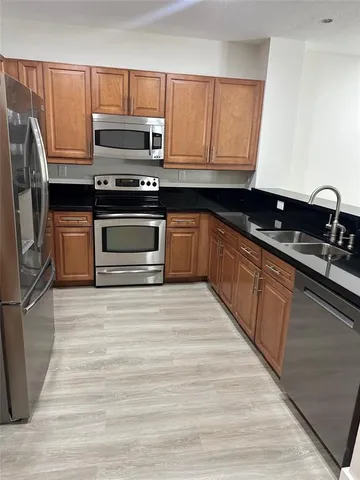 a kitchen with granite countertop wooden cabinets and stainless steel appliances