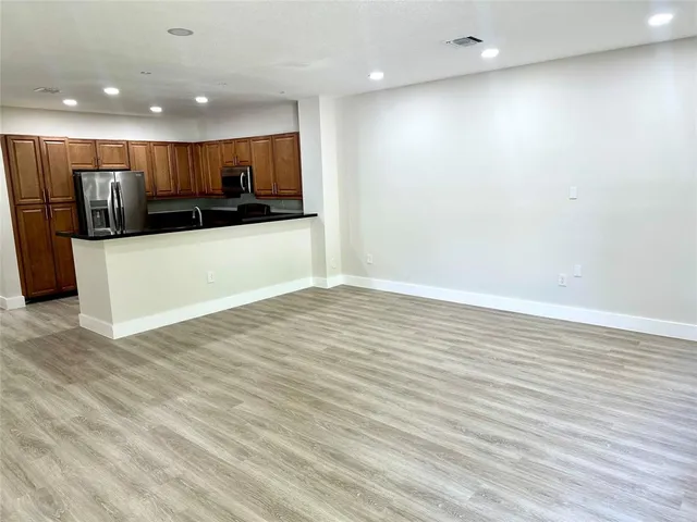 a view of kitchen with stainless steel appliances a refrigerator and a microwave