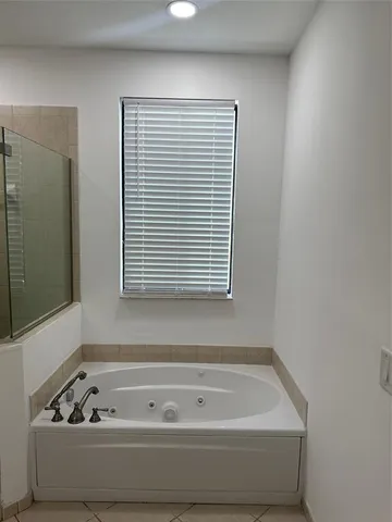a bathroom with a bathtub and next to a window