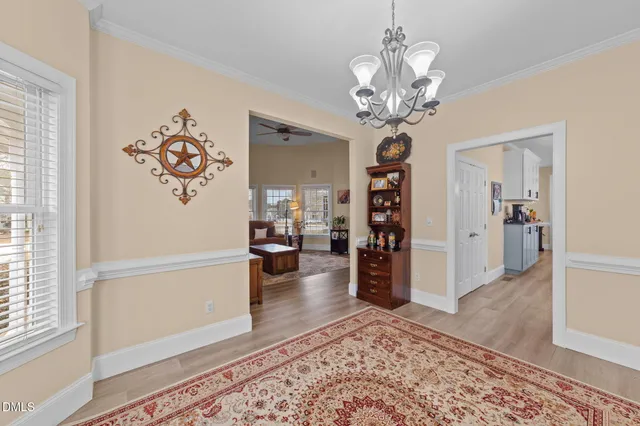 a kitchen with stainless steel appliances granite countertop a stove top oven a sink a dining table and chairs with wooden floor