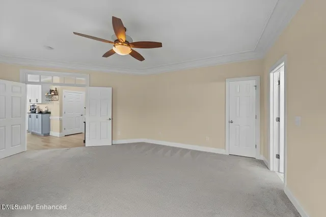 a bedroom with a large bed and a flat tv screen on dresser