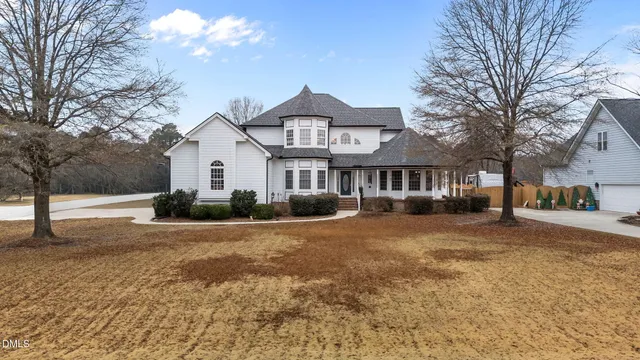 a front view of a house with a yard and trees
