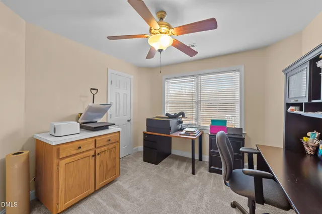 a view of a workspace with furniture and a window