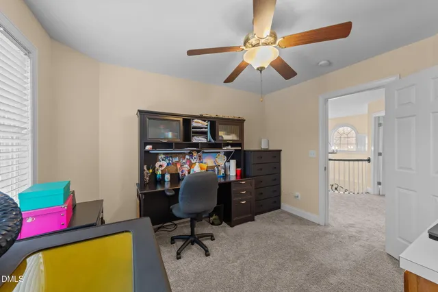 a view of a workspace with furniture and a window