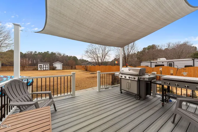 a view of a house with large windows plants and large tree