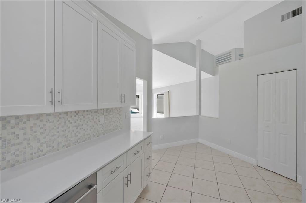 11054 Linnet Lane Naples, FL 34119 - Photo 16 of 50 a view of a kitchen with white cabinets and a stove top oven