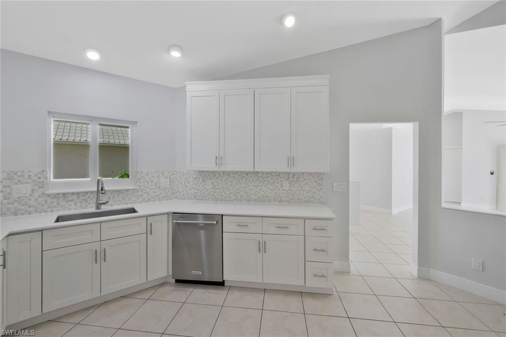 11054 Linnet Lane Naples, FL 34119 - Photo 17 of 50 a kitchen with white cabinets appliances and sink