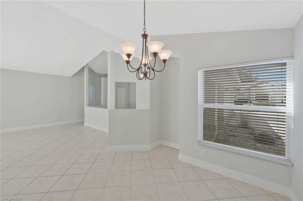 11054 Linnet Lane Naples, FL 34119 - Photo 20 of 50 a view of empty room with wooden floor and chandelier