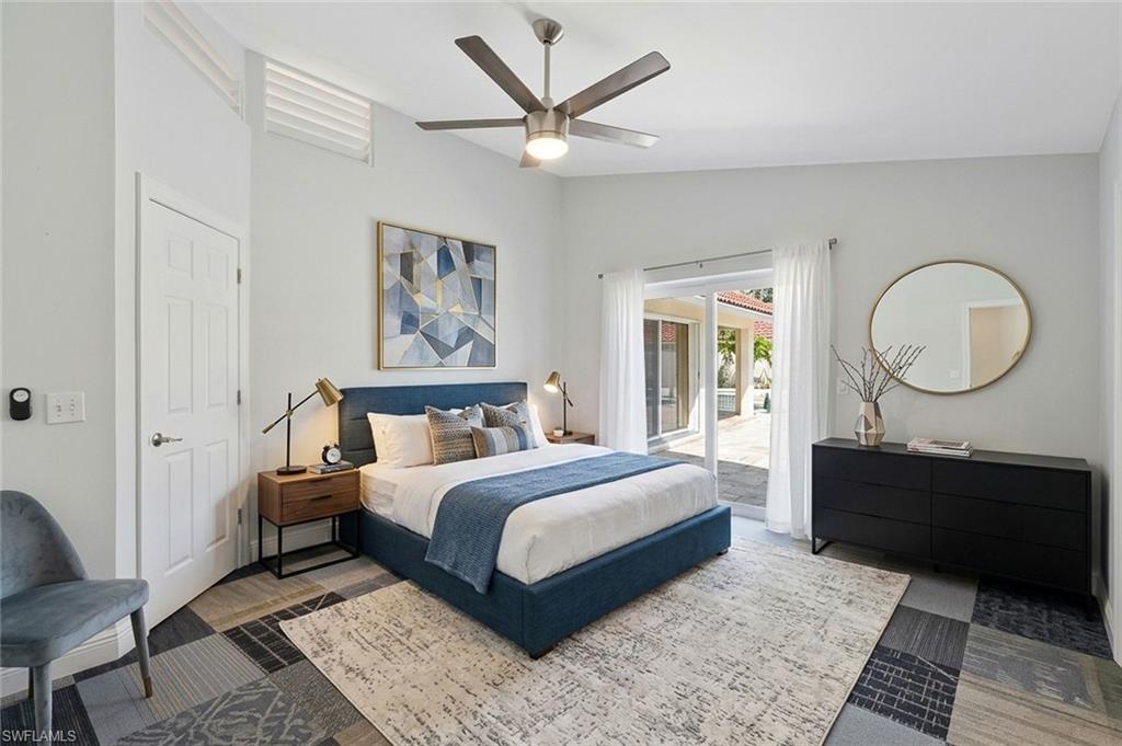 11054 Linnet Lane Naples, FL 34119 - Photo 27 of 50 a bedroom with a large bed and a chandelier