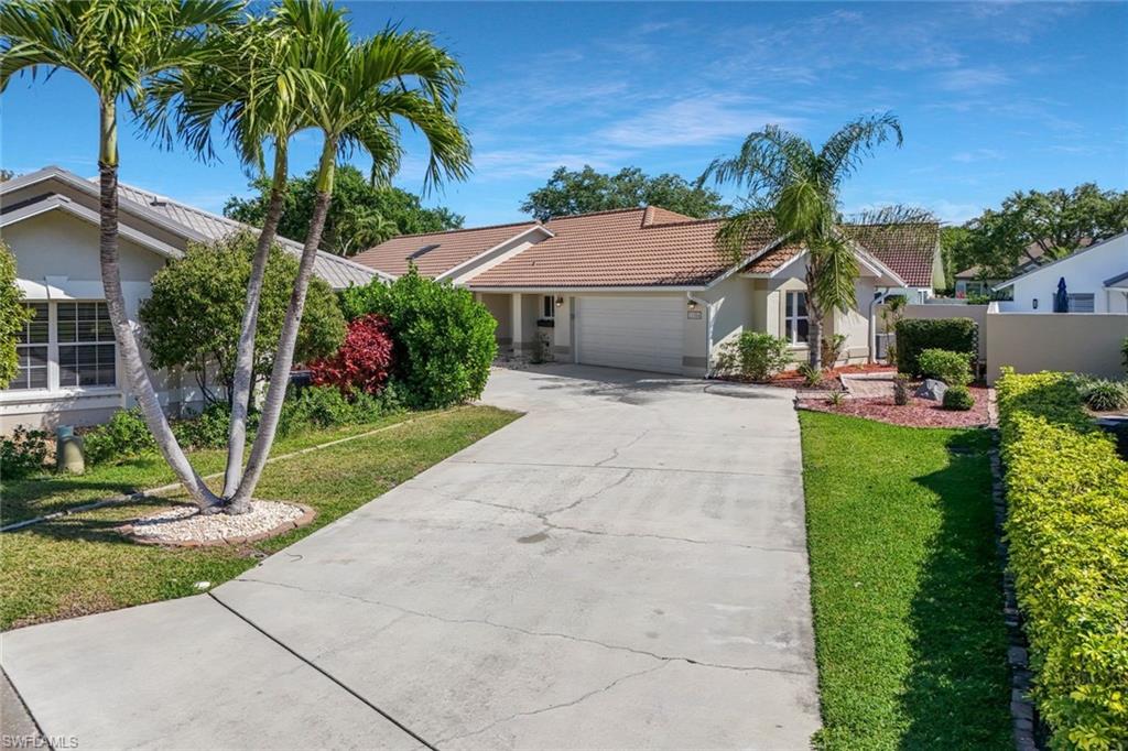 11054 Linnet Lane Naples, FL 34119 - Photo 44 of 50 a front view of a house with a yard and potted plants