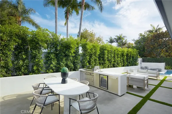 a patio with a table and chairs and potted plants