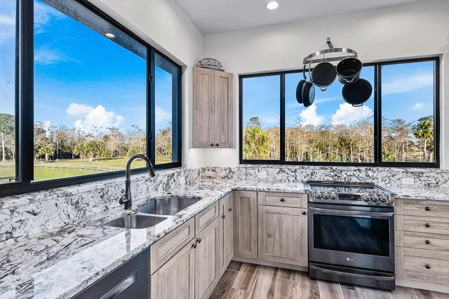 a living room with stainless steel appliances furniture a flat screen tv and a refrigerator