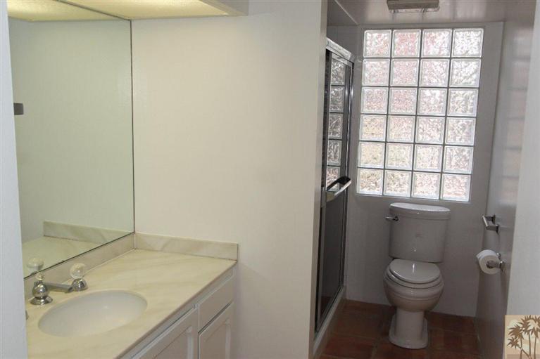 71371 Biskra Road Rancho Mirage, CA 92270 - Photo 36 of 39 a bathroom with a granite countertop sink a toilet and a shower