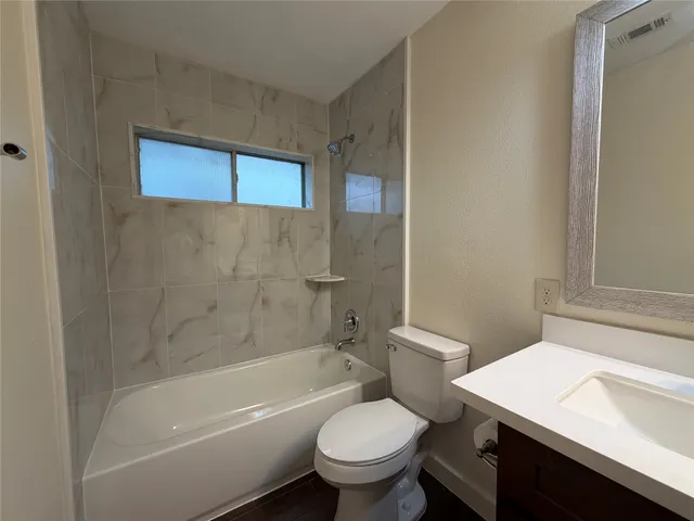 a bathroom with a sink a toilet a mirror and shower