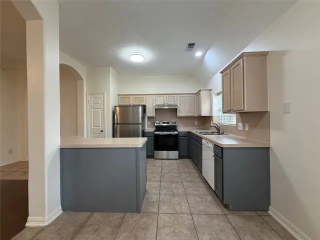 a large kitchen with a large counter top appliances and cabinets