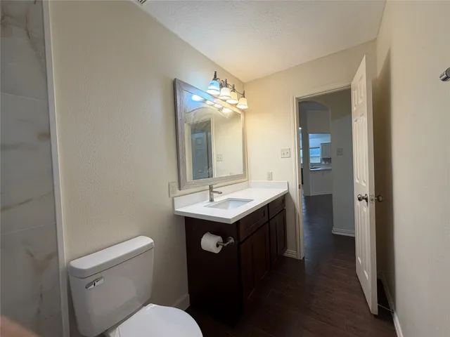 an empty room with wooden floor and chandelier fan