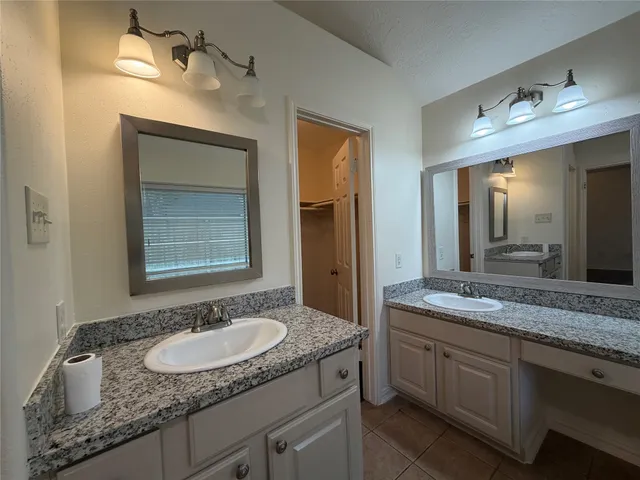 a bathroom with a granite countertop tub shower and sink