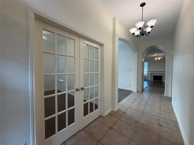 a view of a hallway with windows and chandelier