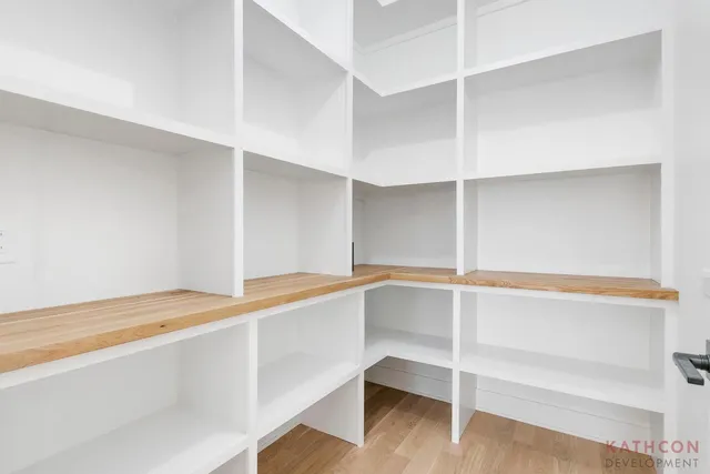 a room with walk in closet and wooden floor