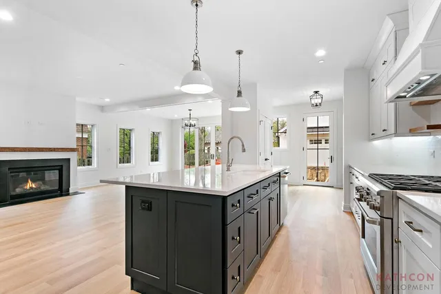 a kitchen with stainless steel appliances granite countertop a sink a stove and a wooden floors