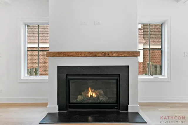 a living room with a fireplace a lamp and a window