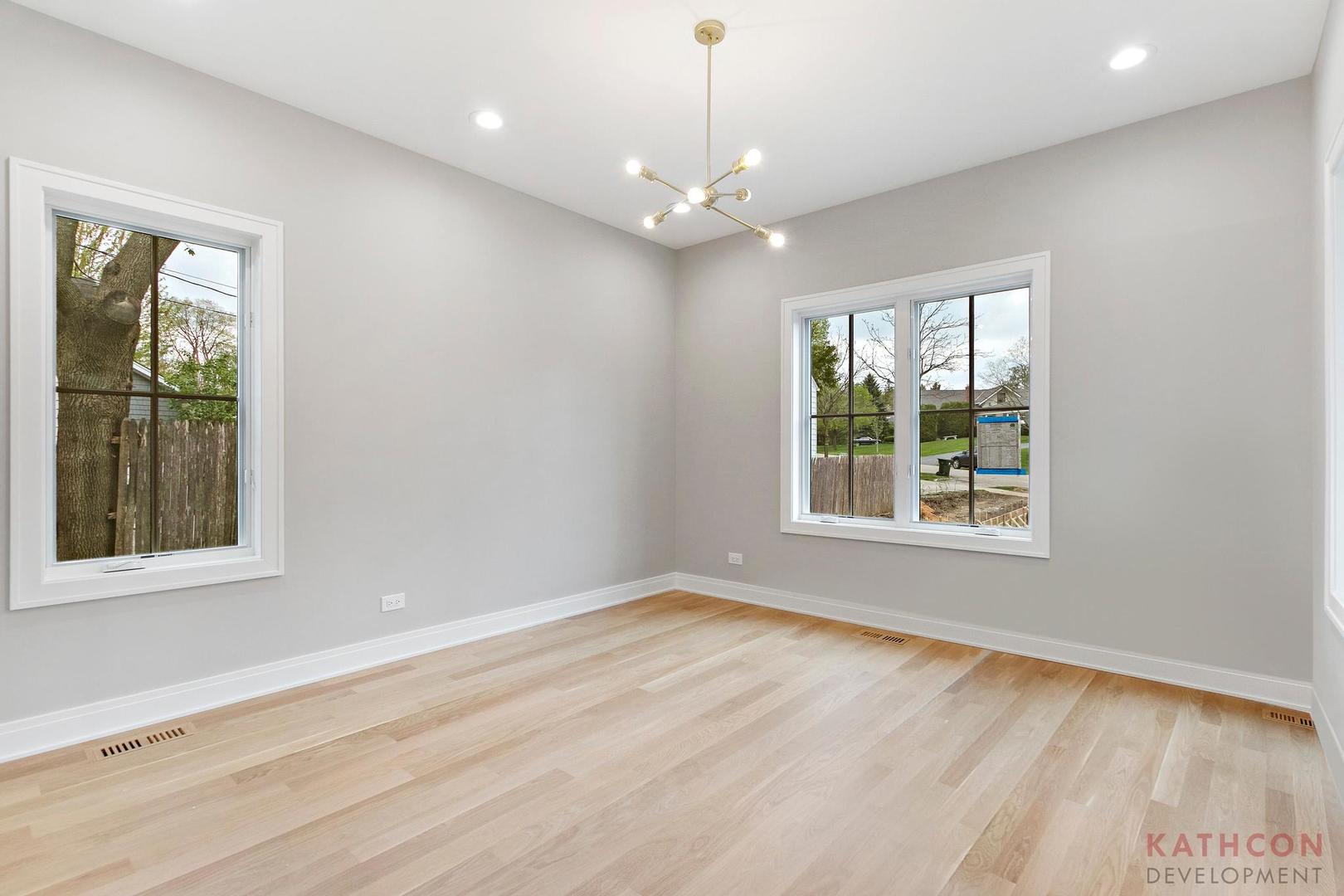 650 Sanders Road Northbrook, IL 60062 - Photo 23 of 24 an empty room with wooden floor chandelier and windows