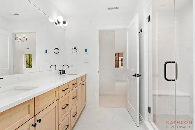 a spacious bathroom with a granite countertop sink a mirror a vanity and shower