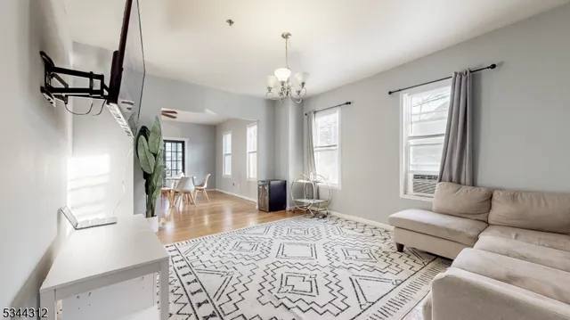 a living room with furniture windows and a chandelier
