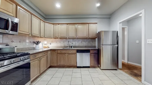 a kitchen with stainless steel appliances granite countertop a refrigerator sink and stove