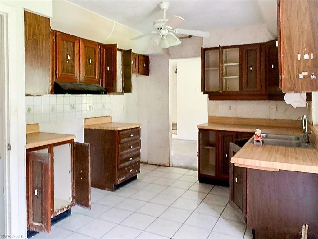 5975 Green Boulevard Naples, FL 34116 - Photo 7 of 20 a kitchen with a stove sink and a refrigerator