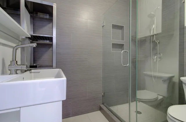 a bathroom with a sink a toilet and shower