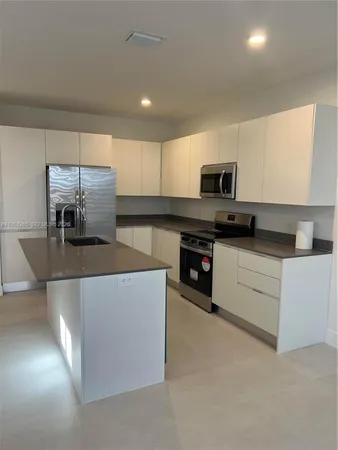 a kitchen with stainless steel appliances a stove a sink and a microwave
