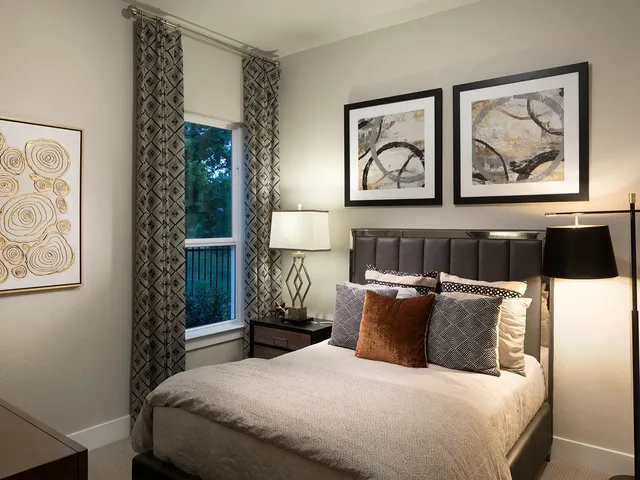 a bedroom with a bed and a painting on the wall