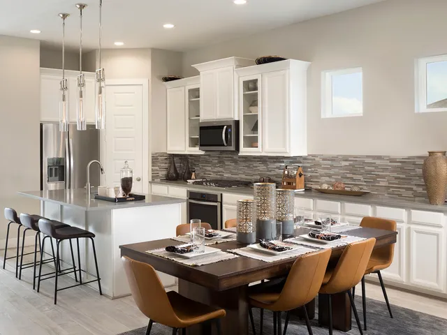 a kitchen with a table chairs stove and refrigerator