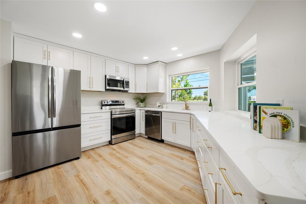 656 Mehlenbacher Road Belleair, FL 33756 - Photo 11 of 49 a kitchen with a refrigerator a sink and a stove top oven