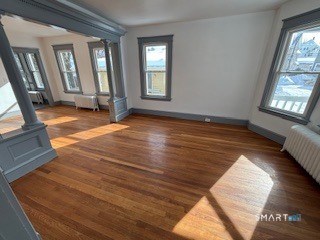 14 Guilfoile Street, Unit 2 Waterbury, CT 06708 - Photo 1 of 17 a view of an empty room with wooden floor and a window