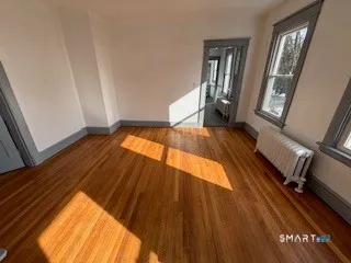 a view of an empty room with wooden floor