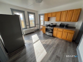 14 Guilfoile Street, Unit 2 Waterbury, CT 06708 - Photo 5 of 17 a kitchen with granite countertop wooden cabinets a sink a window and stainless steel appliances