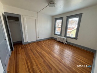14 Guilfoile Street, Unit 2 Waterbury, CT 06708 - Photo 8 of 17 an empty room with wooden floor and windows