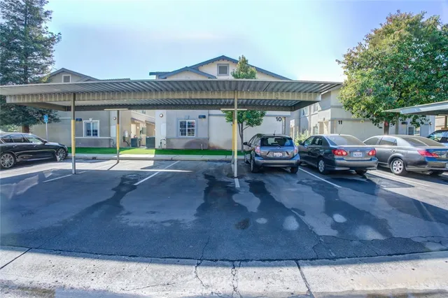 an aerial view of a residential apartment building with a yard and mountain view in back
