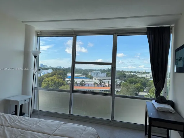 a view of a room that has a large window and a flat screen tv