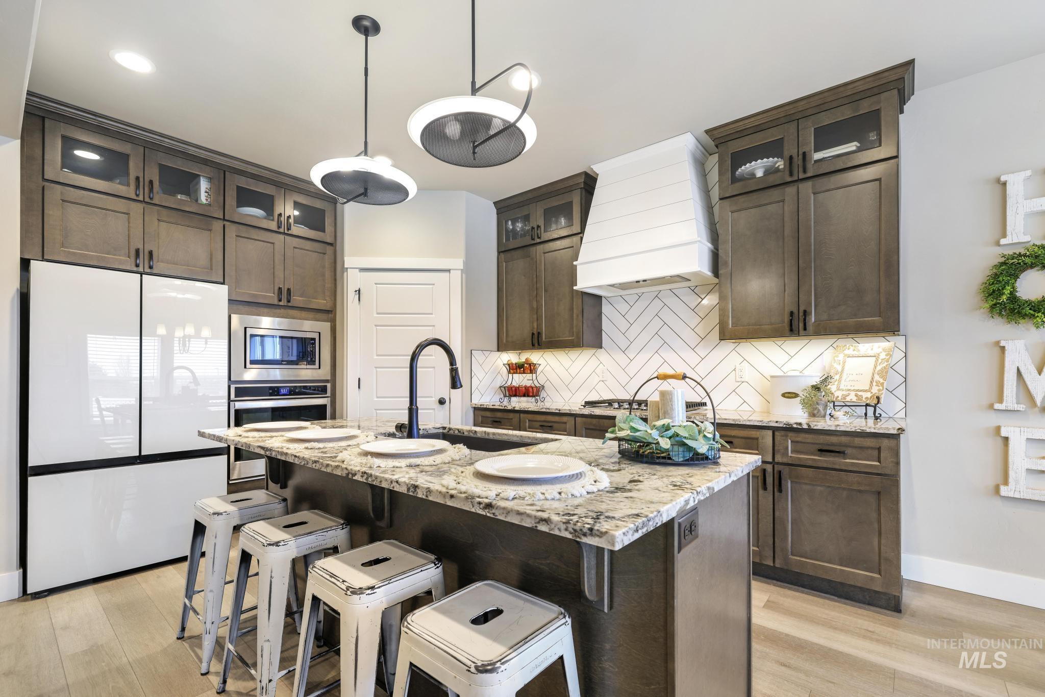 3103 Moonrise Road Twin Falls, ID 83301 - Photo 6 of 40 Kitchen featuring stainless steel appliances, light stone counters, and dark wood finish cabinets