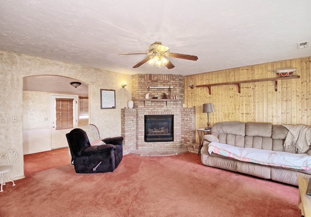 1066-19 19 1/2 Road Fruita, CO 81521 - Photo 31 of 42 a living room with furniture a fireplace and a chandelier