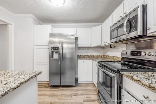 a kitchen with stainless steel appliances granite countertop a stove a refrigerator and a granite counter tops
