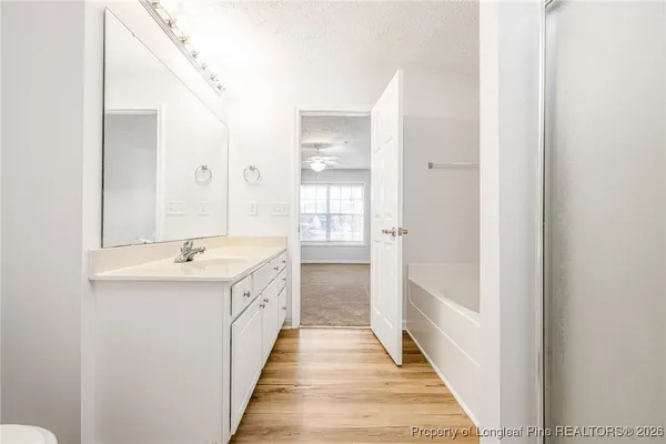 a hallway with white cabinets and white appliances
